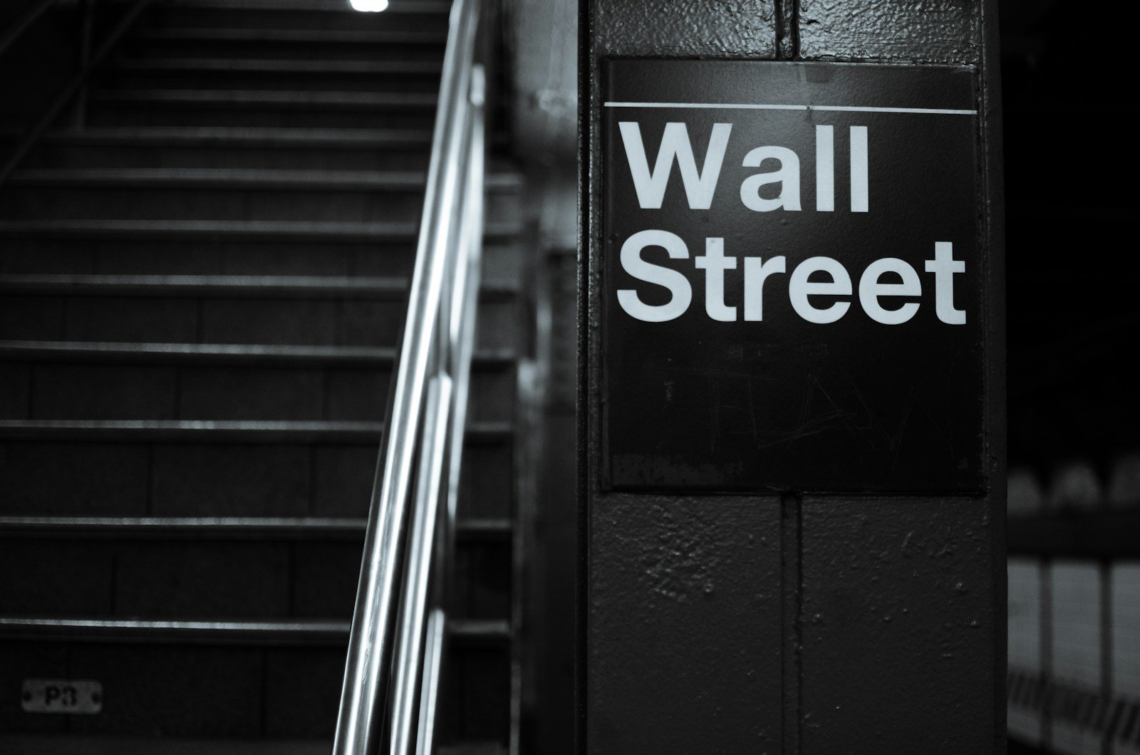 a black and white photo of a wall street sign